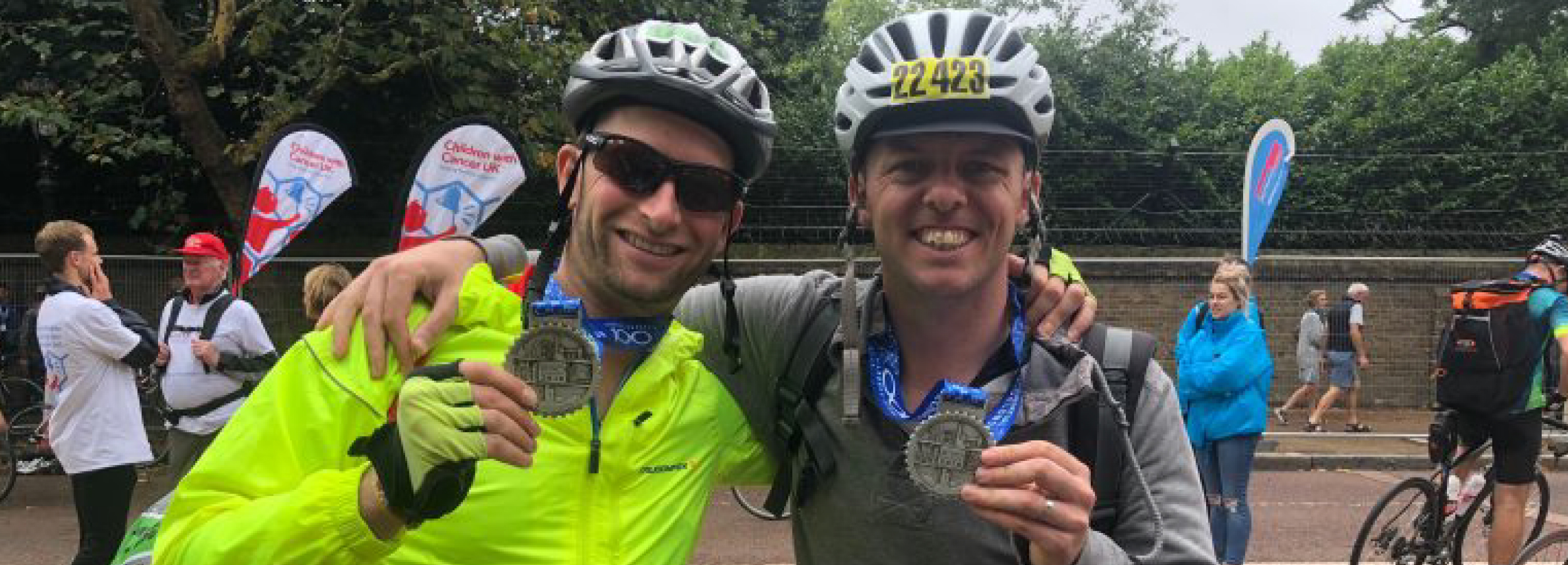 holding medals after completing cycle ride